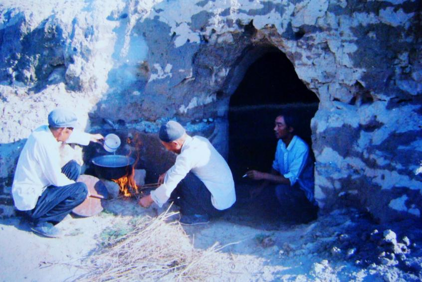 1983年，“六老漢”一代治沙人在“地窩子”生活做飯。新華社發(fā)（八步沙林場(chǎng)供圖）