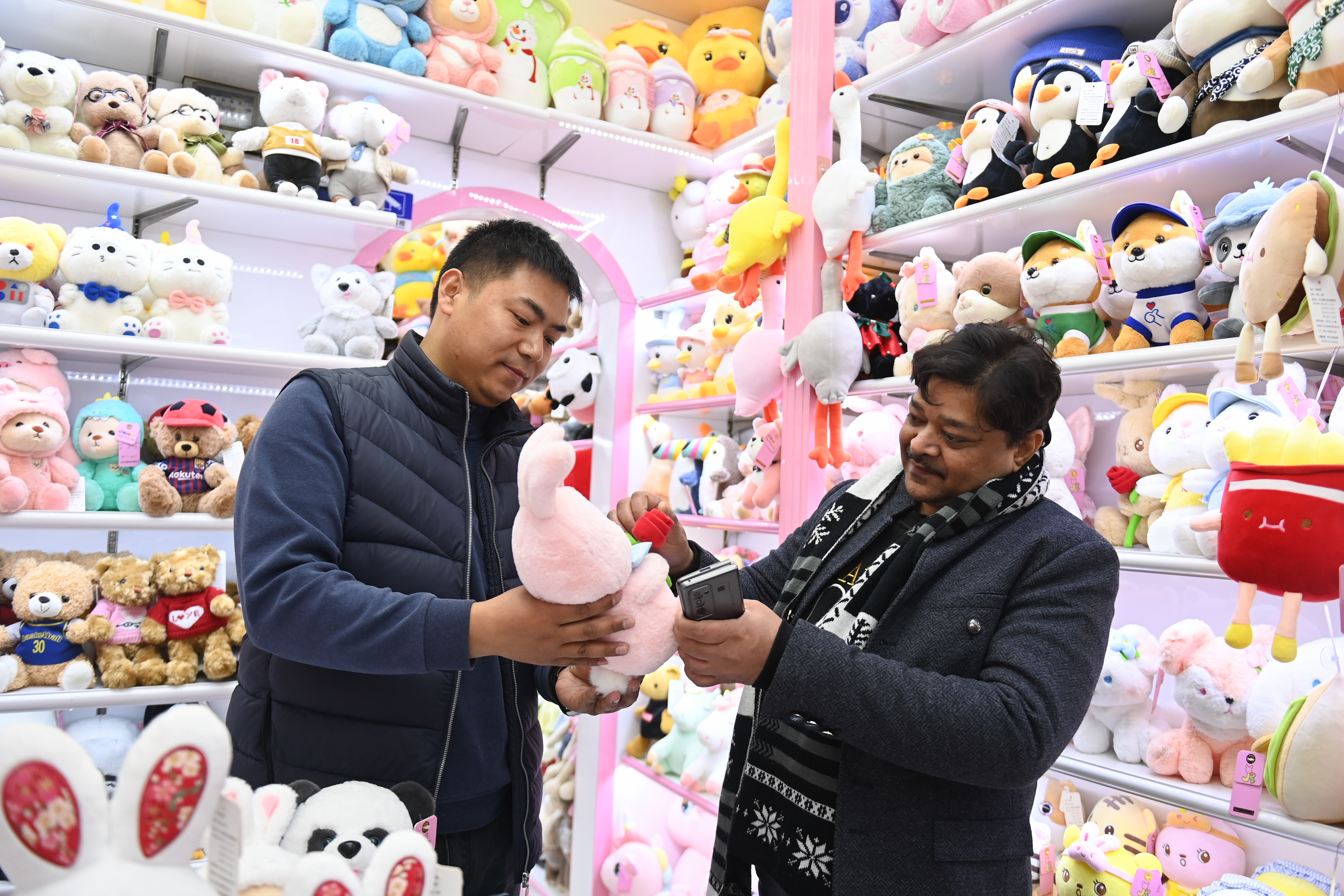 2023年2月2日，來(lái)自印度的客商（右）在義烏國際商貿城的一家玩具店鋪內選購。